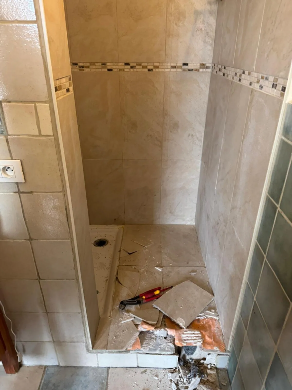 Douche tijdens het werk: oude vloertegels eruit en de afvoer zichtbaar
