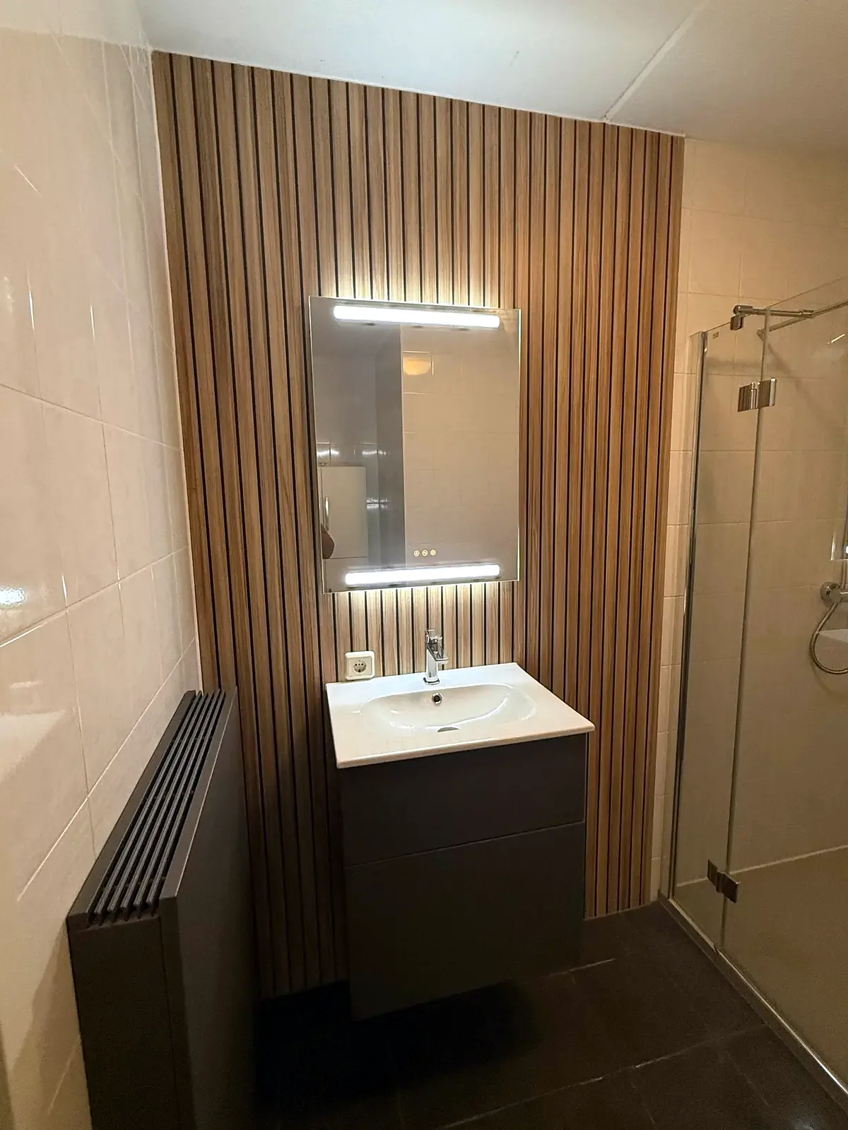 Badkamer met glazen douche en hangtoilet