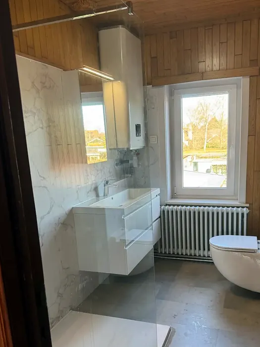 Na: drempelloze inloopdouche met marmerlook wanden op de plek van het bad